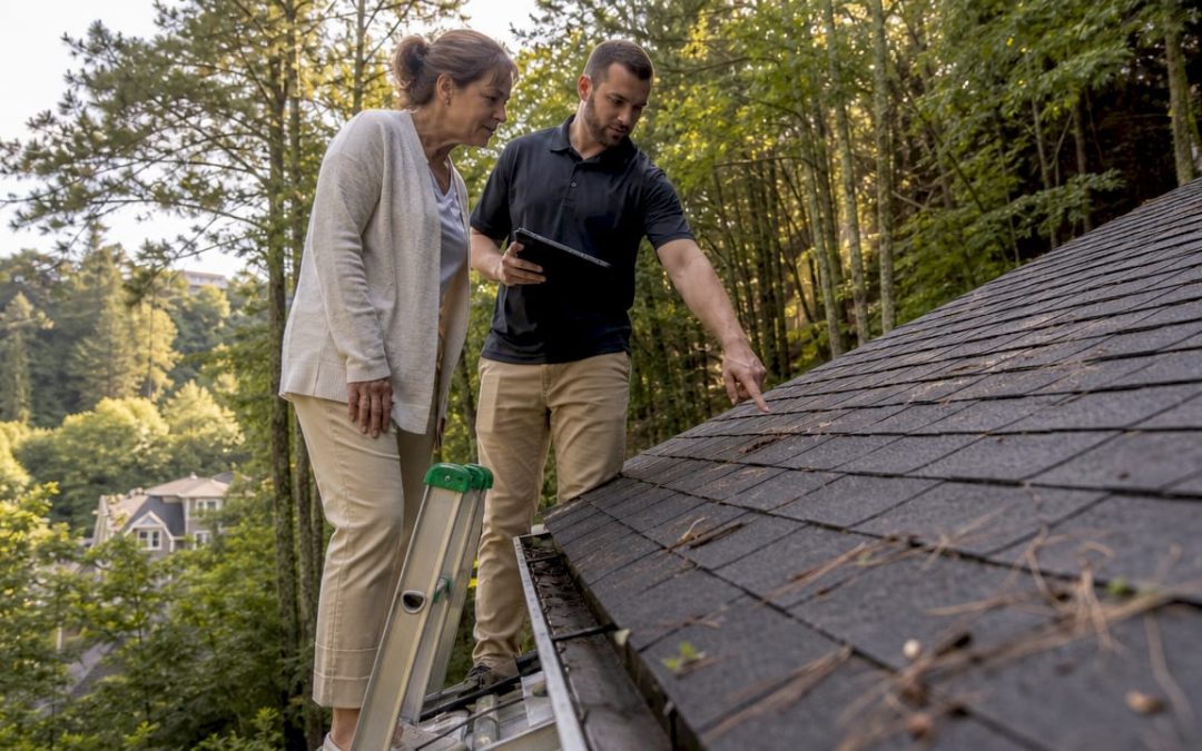 Homeowner and inspector examining roof shingles