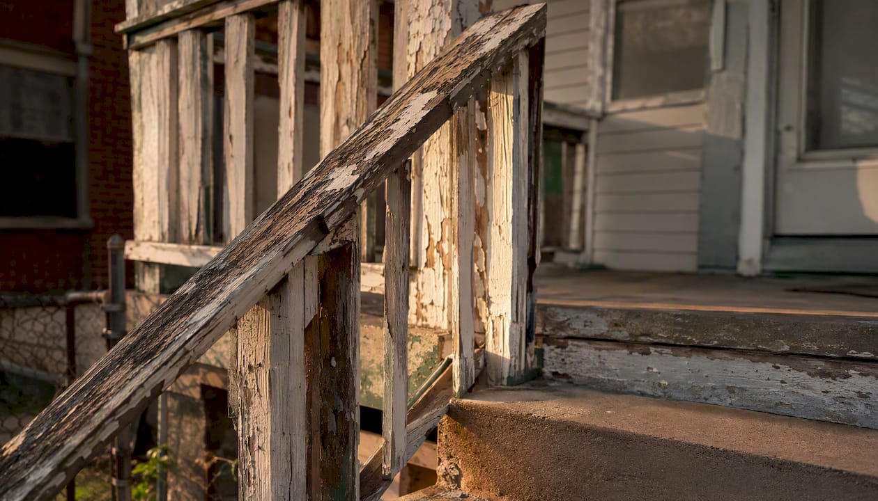 Exterior corner of older HUD-owned home with wear