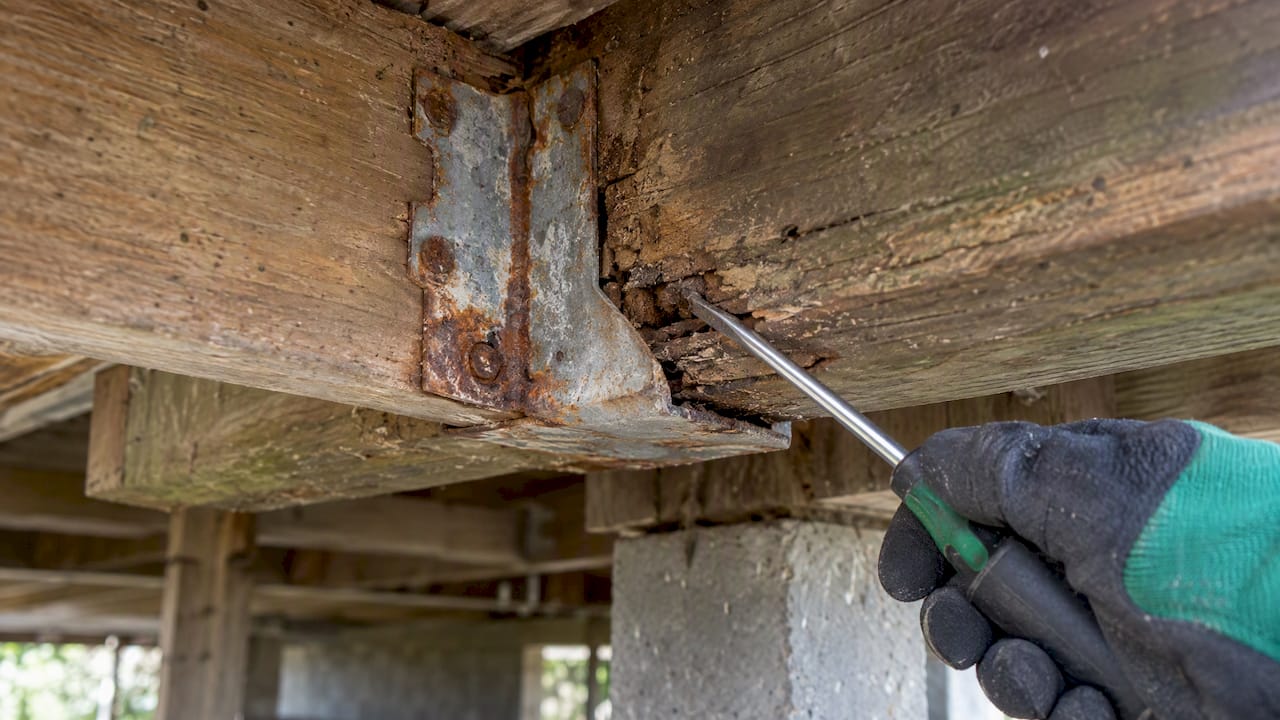 Corroded joist hanger beneath deck